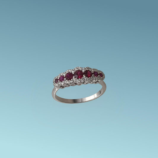 anello con Rubini in oro bianco 18kt di Mirco Visconti presenta una fila di 7 rubini naturali taglio brillante a scalare ai due lati del rubino centrale per un totale di 0.68 ct. Intorno ai rubini una coroncina di diamanti naturali taglio brillante per un totale di 0.21 ct,