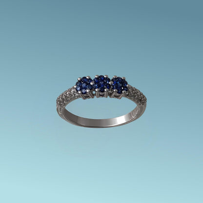Anello trilogy di Meteore Gioielli con tre rose di Zaffiri naturali taglio brillante sapientemente incassati da sembrare tre uniche pietre per un totale di 0.26 ct montate su un gambo in cui è incassato un luminoso pavé di diamanti naturali taglio brillante per un totale do 0.20 ct.