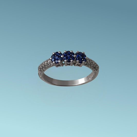 Anello trilogy di Meteore Gioielli con tre rose di Zaffiri naturali taglio brillante sapientemente incassati da sembrare tre uniche pietre per un totale di 0.26 ct montate su un gambo in cui è incassato un luminoso pavé di diamanti naturali taglio brillante per un totale do 0.20 ct.