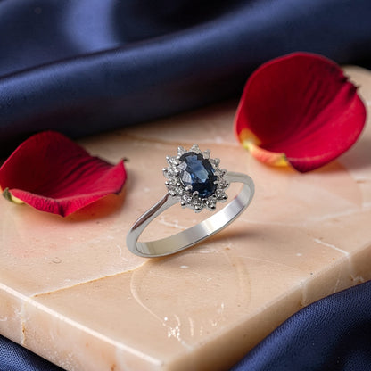 Anello in oro 18 kt con zaffiro naturale ovale da 0,58 carati e contorno di diamanti taglio brillante da 0,12 carati totali.