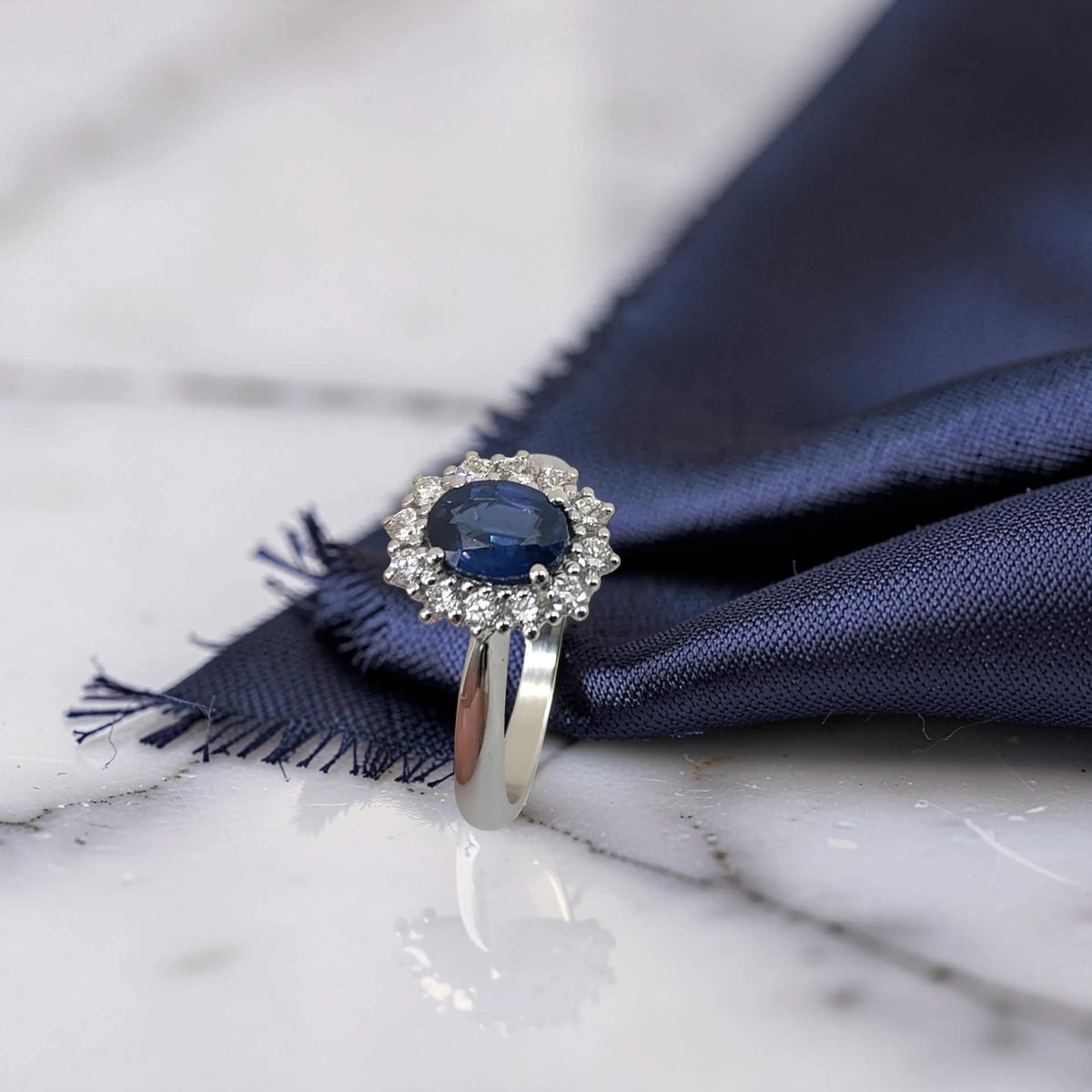 anello halo con zaffiro blu e diamanti in oro bianco 18kt, vista di profilo