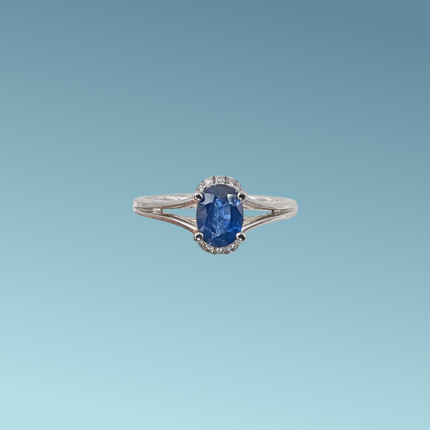 anello in oro bianco 18kt di meteore gioielli con zaffiro naturale taglio ovale ct 1.04 dal blu intenso incassato su un cestello impreziosito da sei piccoli diamanti naturali taglio brillante, per un totale di 0.08 ct, visto da sopra