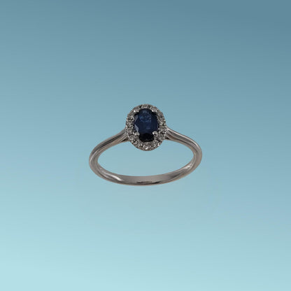 Anello in oro bianco 18kt di Meteore Gioielli con Zaffiro naturale taglio ovale ct 0.46 contornato da un giro di diamanti naturali taglio brillante ct 0.13 G/V