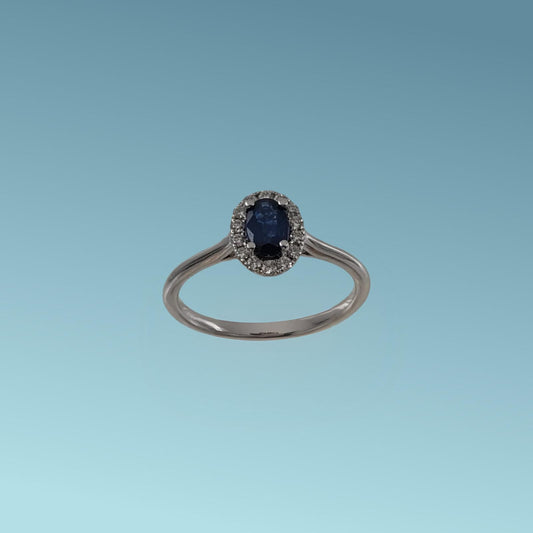 Anello in oro bianco 18kt di Meteore Gioielli con Zaffiro naturale taglio ovale ct 0.46 contornato da un giro di diamanti naturali taglio brillante ct 0.13 G/V