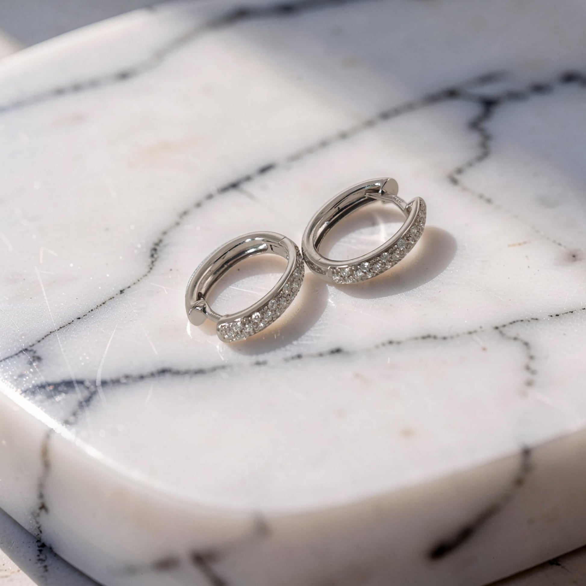 Orecchini in oro bianco 18kt di Mirco Visconti a forma di cerchio ovale con pavè di diamanti naturali taglio brillante G/VS per un totale di 0.22 ct.