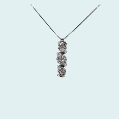 Collana con pendente a forma di trilogy in oro bianco 18 carati e diamanti. 3 cerchietti di diamanti avvolti da un filo d'oro che si intreccia nel gioiello