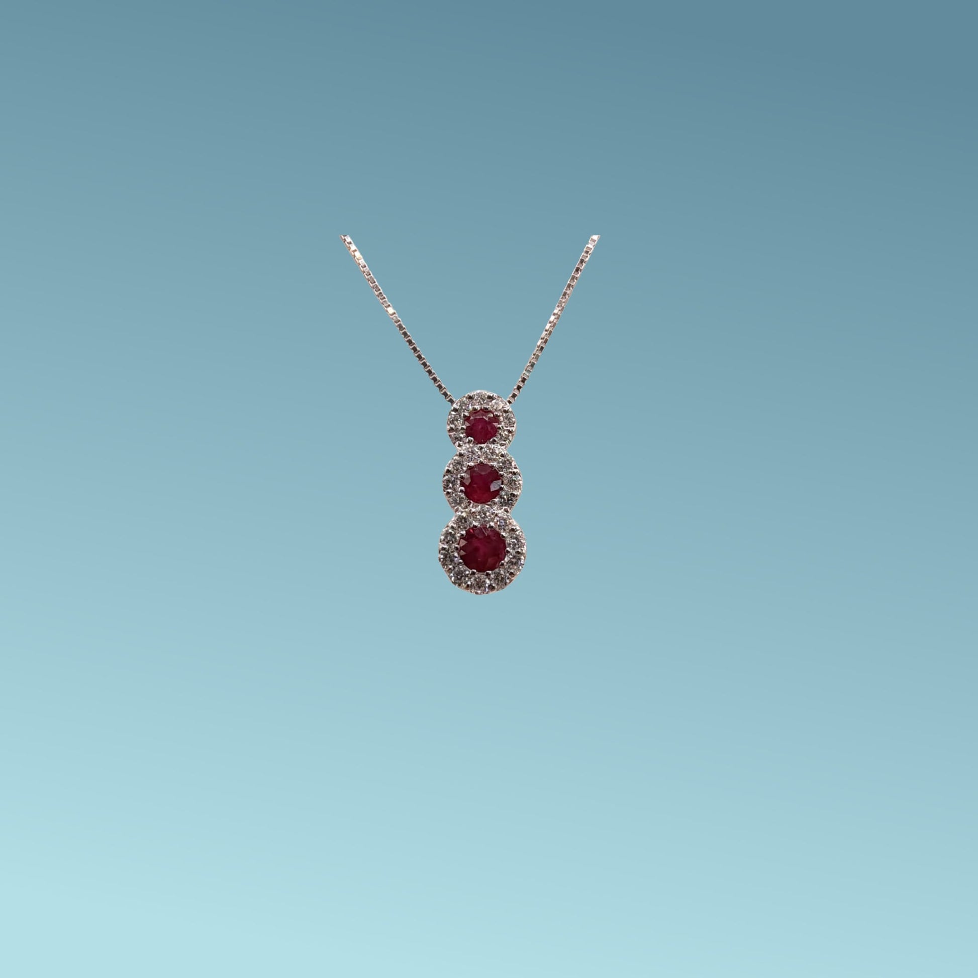 Collana trilogy in oro bianco 18kt di Meteore Gioielli con tre rubini tondi naturali ct0.34 montati a scalare circondati da diamanti naturali  0.22ct .