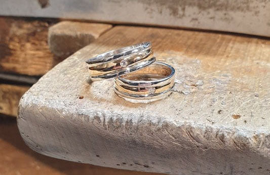 fedi create a mano con ai lati 2 fili girati in oro bianco e al centro un diamante, ideali per 25 anni di matrimonio