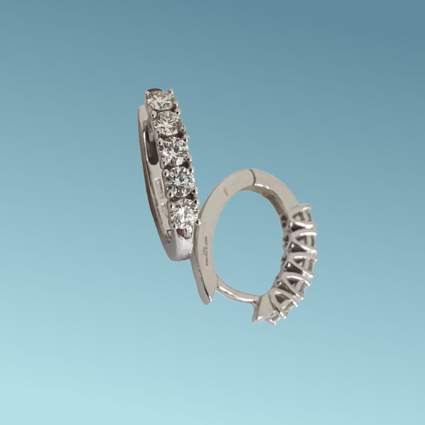 orecchini a cerchio ovale in oro bianco 18kt di mirco visconti presentano una fila di 5 diamanti naturali taglio brillante per un totale di 0.88 ct incassati su castoni a filo su base tond