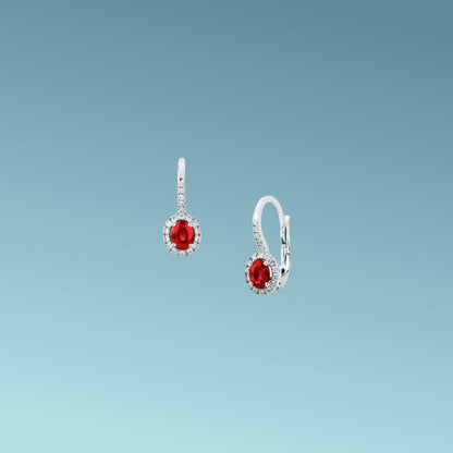 Orecchini in oro bianco 18kt di Mirco Visconti con chiusura a gancio pendente, presentano una coppia di rubini naturali taglio ovale per un totale di 0.87 ct contornati da diamanti naturali taglio brillante presenti anche sulla chiusura per un totale di 0.22 ct