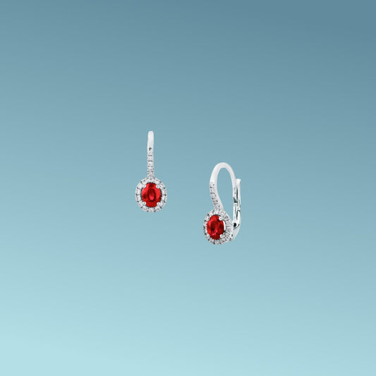 Orecchini in oro bianco 18kt di Mirco Visconti con chiusura a gancio pendente, presentano una coppia di rubini naturali taglio ovale per un totale di 0.87 ct contornati da diamanti naturali taglio brillante presenti anche sulla chiusura per un totale di 0.22 ct