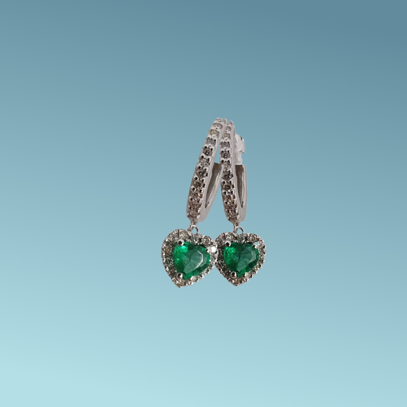 Orecchini di Meteore Gioielli realizzati in oro bianco 18kt con smeraldi naturali con taglio a cuore ct 0.55 e diamanti naturali taglio brillante di ct 0.26.